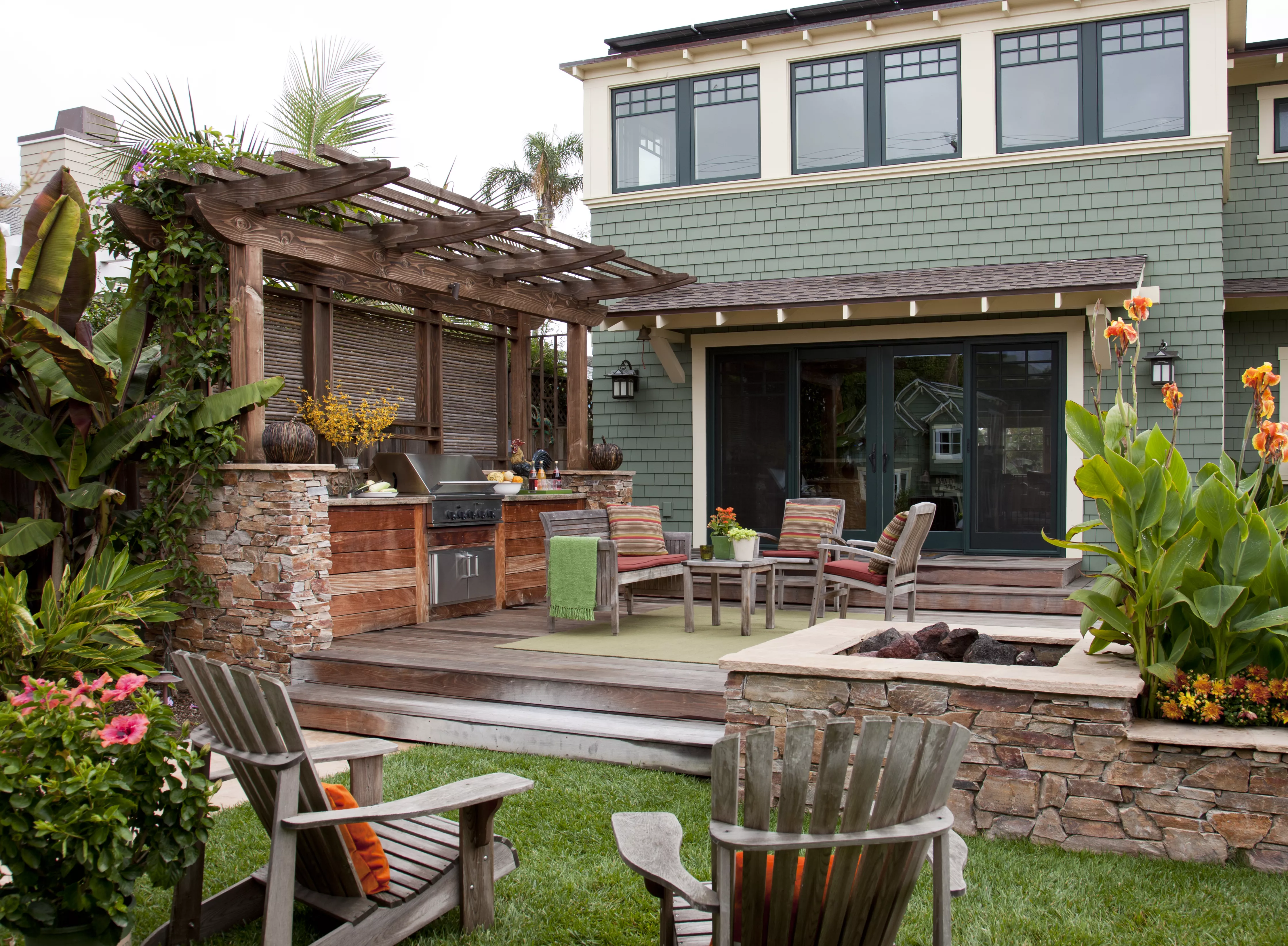 Backyard patio with a fire pit, grill station, and patio furniture