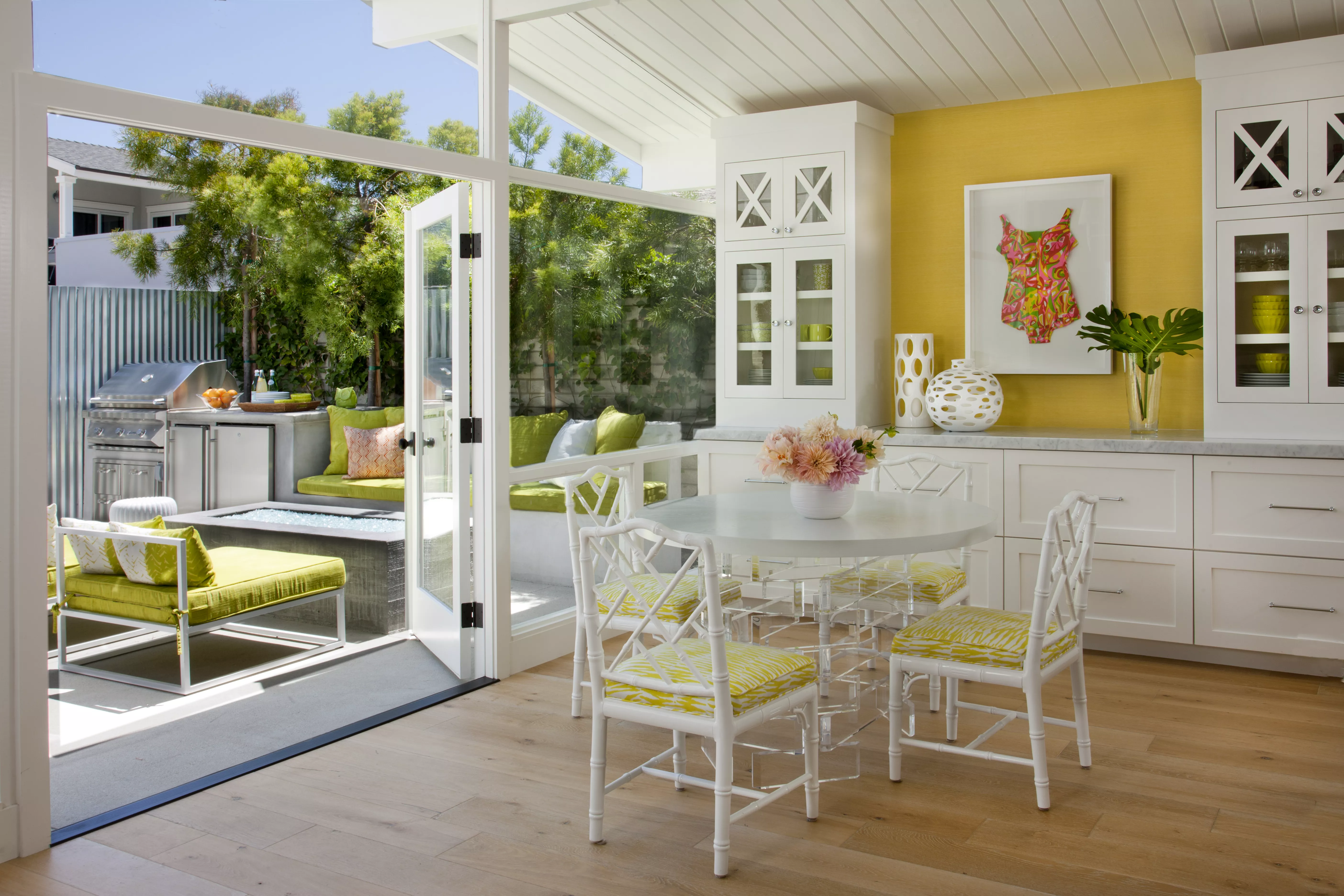 Indoor dining room opening up to backyard patio and grill