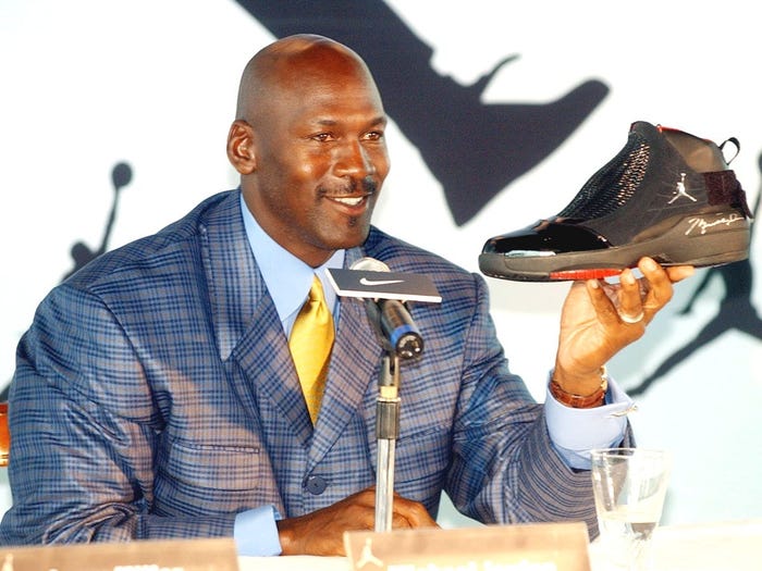 NBA legend Michael Jordan holds up an autographed AJ19 shoe, the latest design in the Air Jordan shoe line, at a Hong Kong news conference. AP:Anat Givon