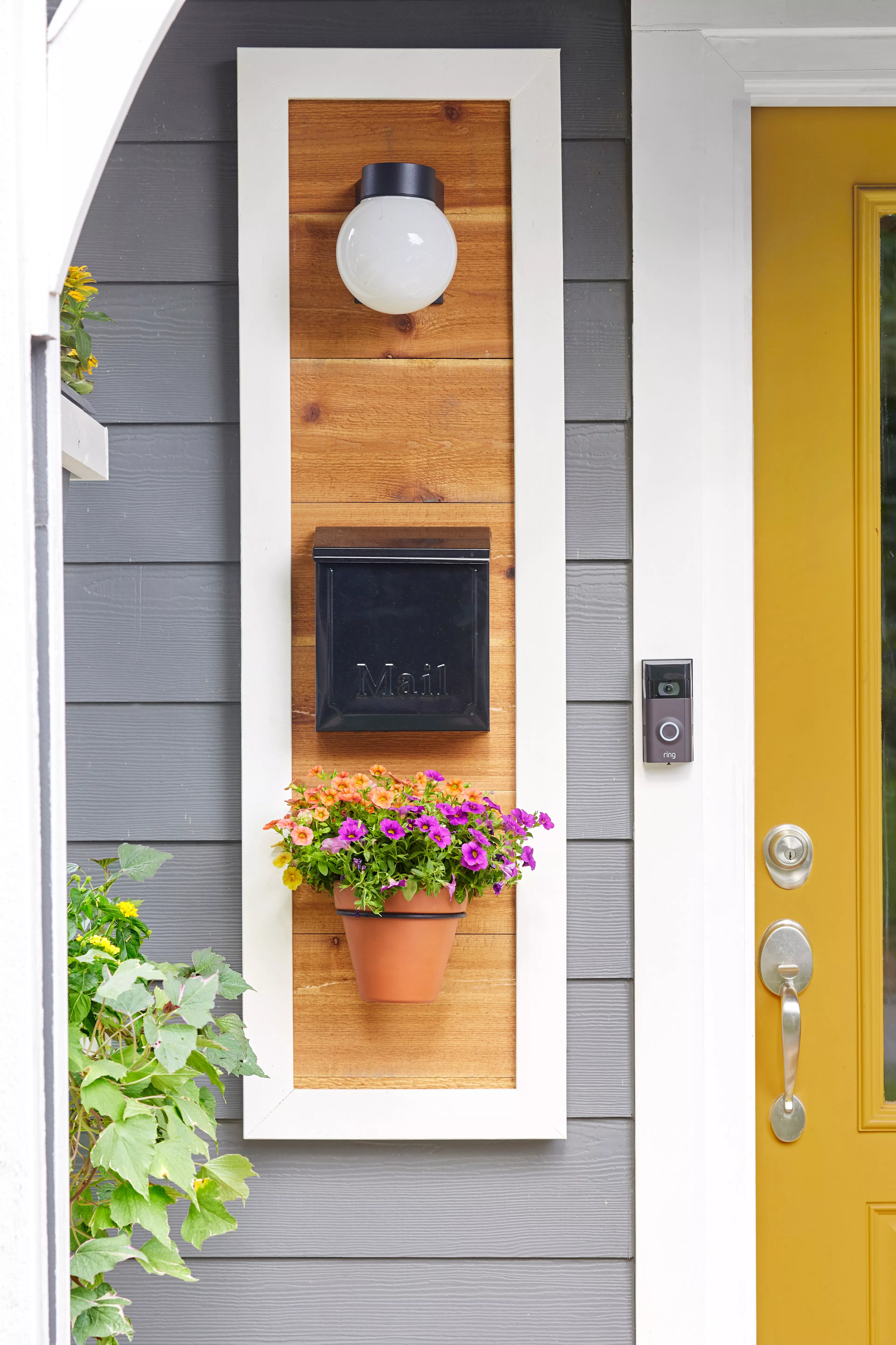 Mailbox with a light and flowerpot by a front door