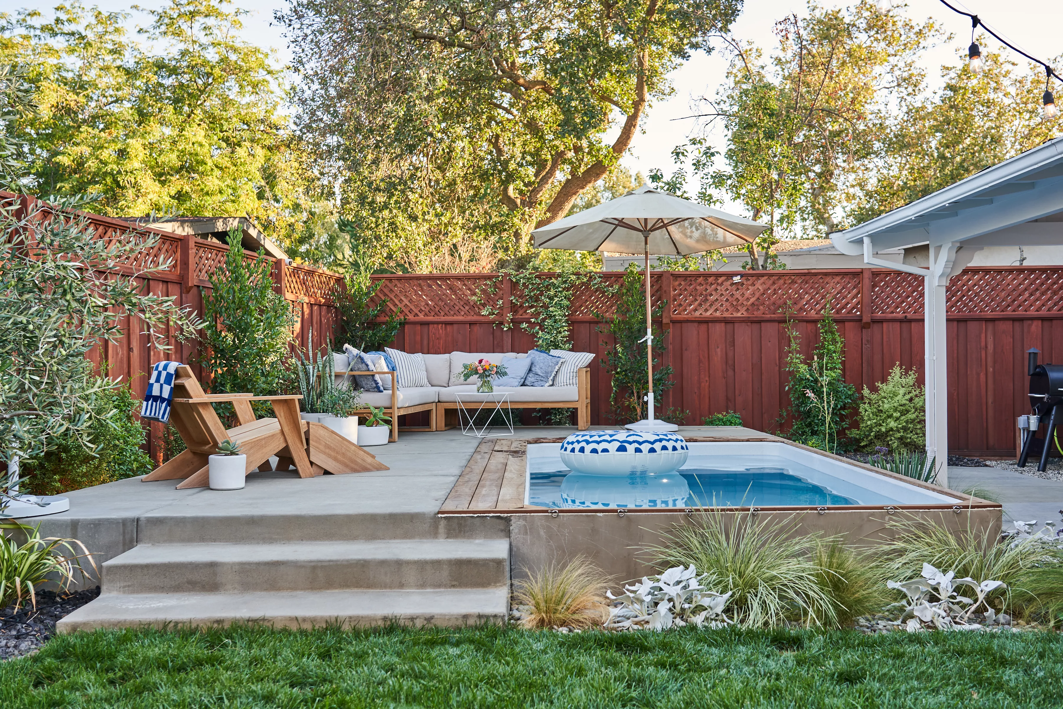 plunge pool with cement pool deck and patio furniture