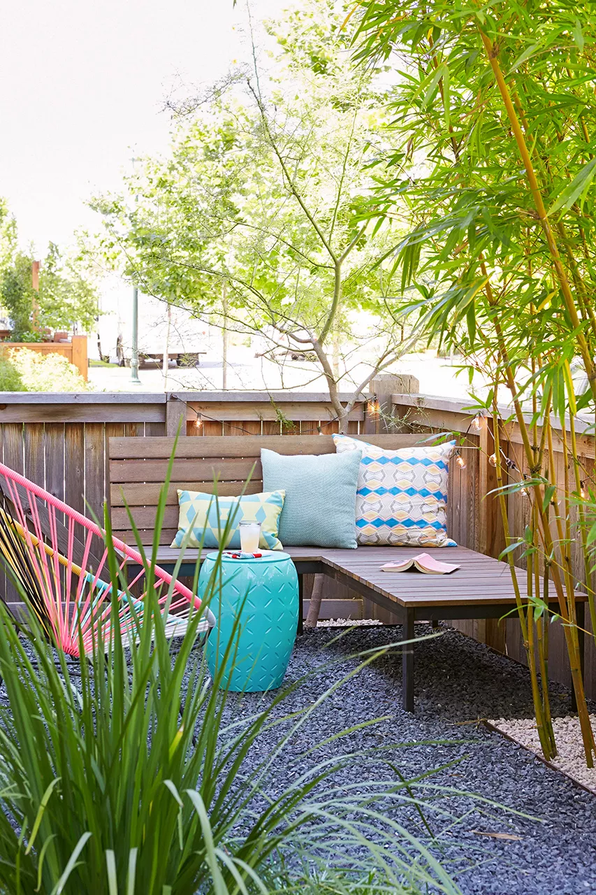 corner bench with pillows, blue table, lounger patio area