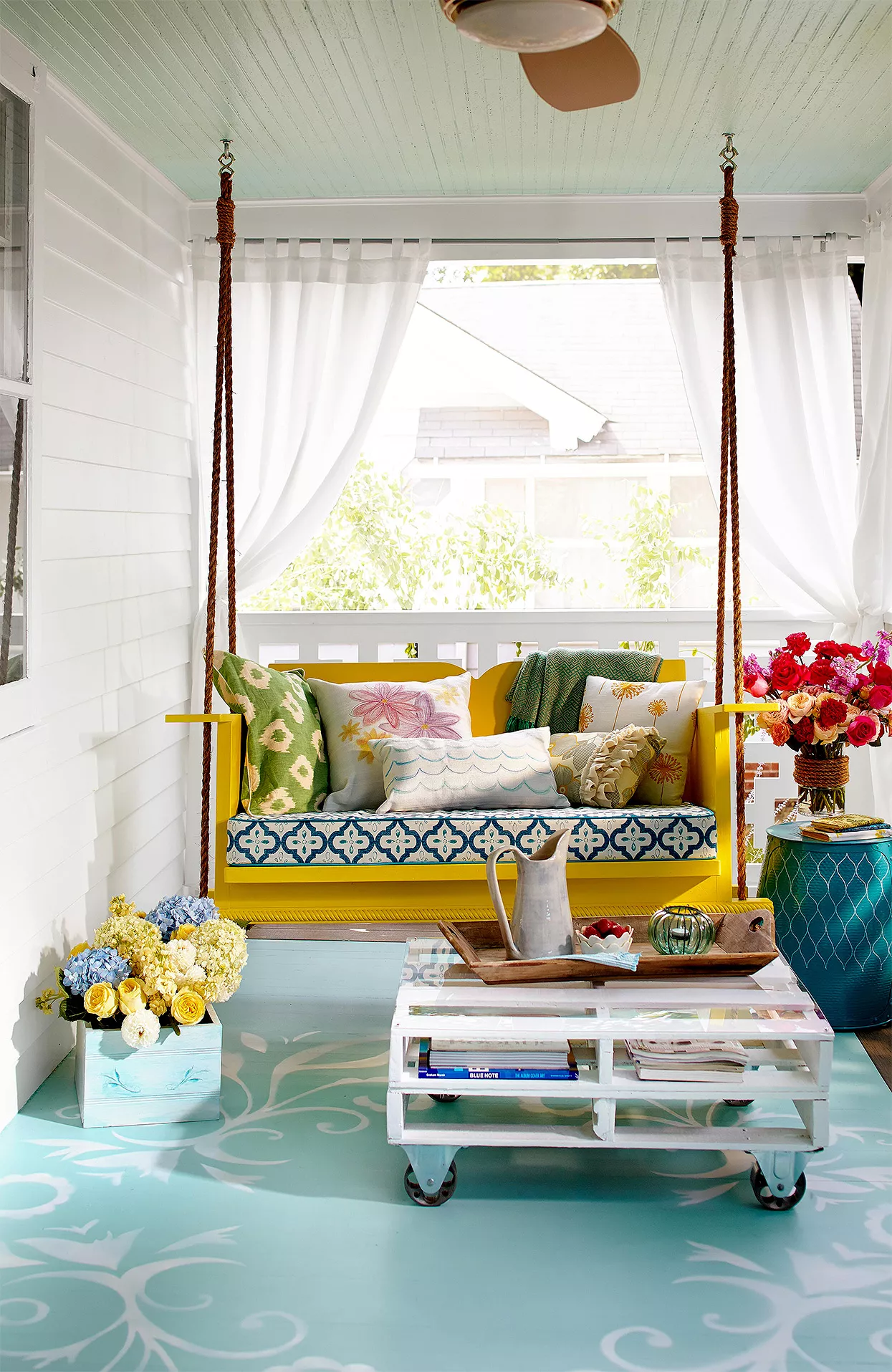 bold front porch with curtains and yellow swing