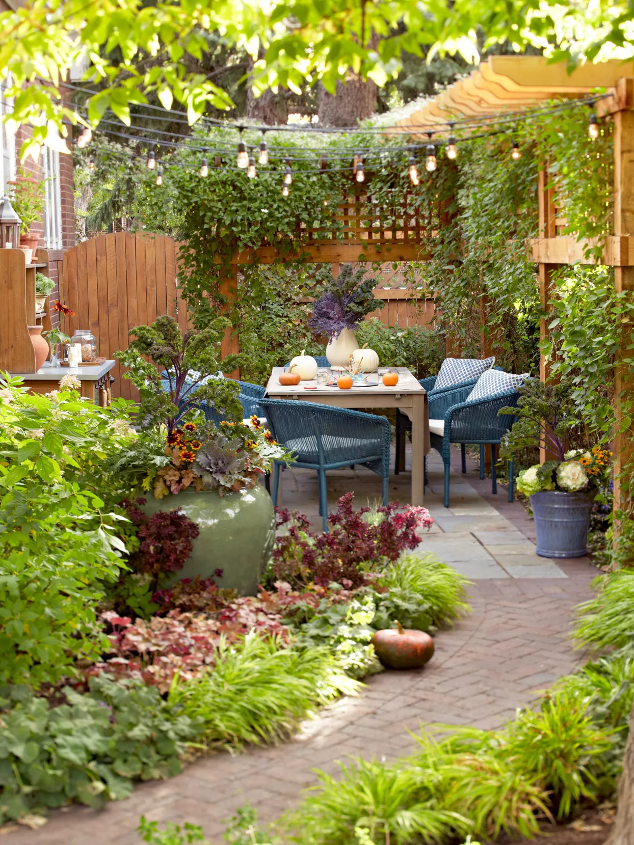 lush garden walk with patio and trellis and string lights