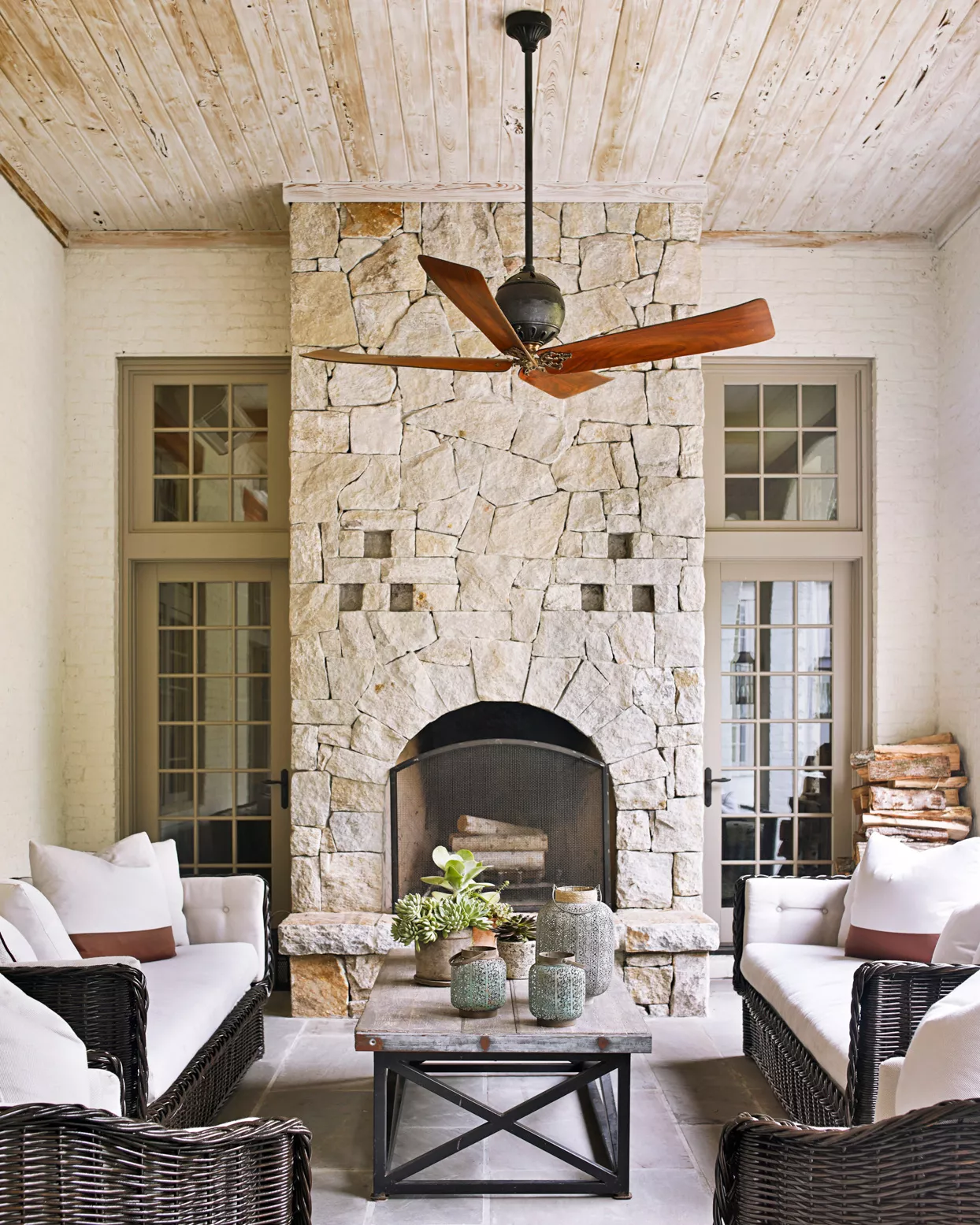 stone fireplace and fan in covered patio