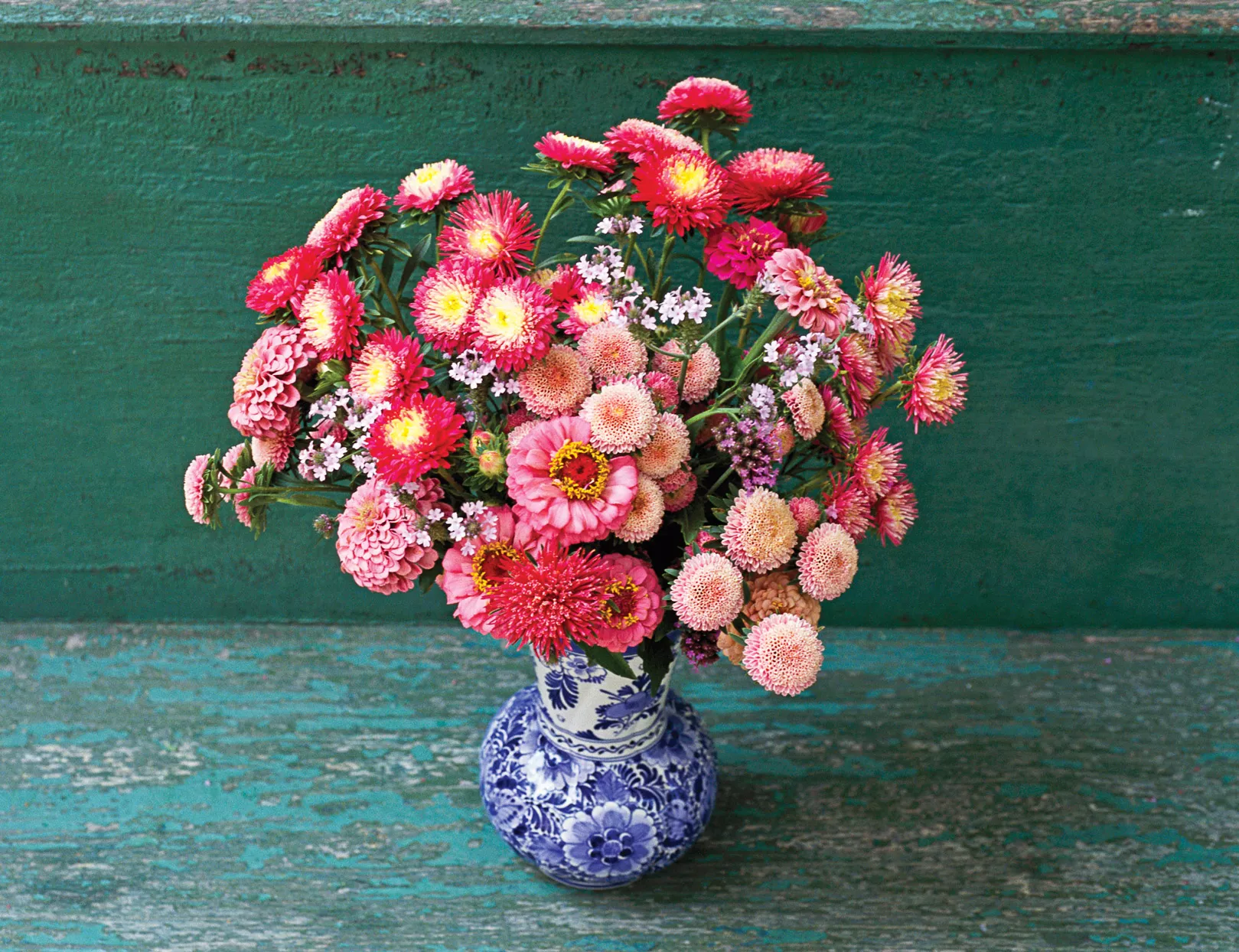 pink red zinnia flower arrangement blue white china vase