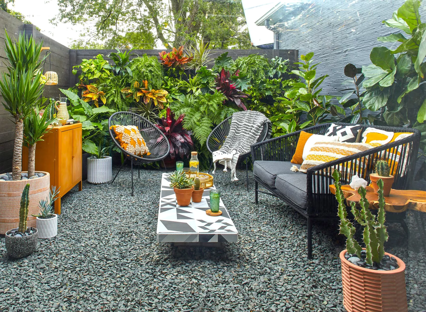 private modern patio tropical plants rock black furniture